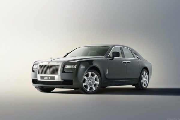 Luxury black Rolls Royce on a solid gray background