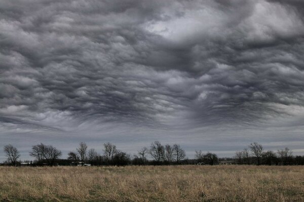 Cloudy clouds against the background of a storm in the field