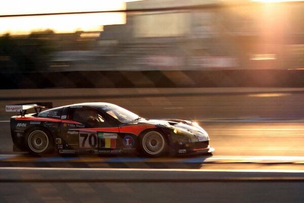 Racing car at speed in the rays of the sun