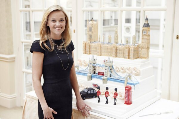 Reese Witherspoon in a black dress and a table with mockups