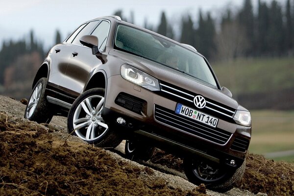 VOLKSWAGEN TOUAREG ON THE BACKGROUND OF BLURRED NATURE