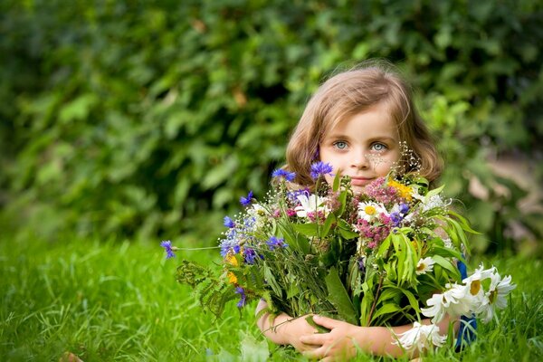 A girl with a large bouquet of meadow flowers