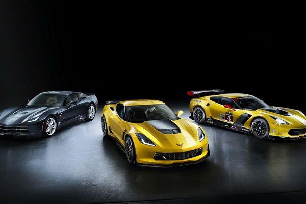 One black and two yellow cars on a black background