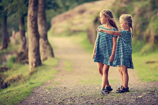 Two girls in nature in identical dresses