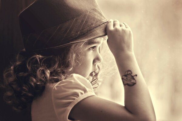 Petite fille dans un chapeau regarde au loin