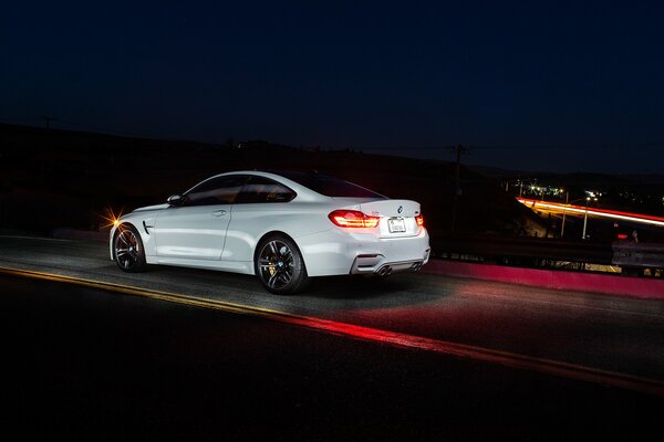 White BMW Coupe F82 on the road at night