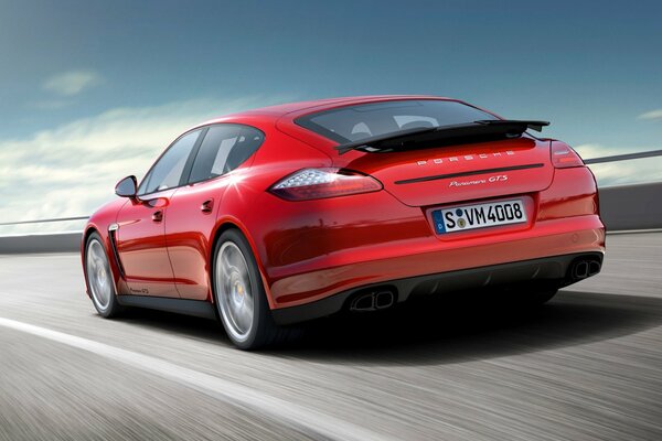 The car is going at speed. A red Porsche. Sports car