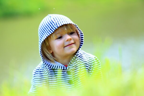 Dziecko w pasiastym kapturze na zielonym tle