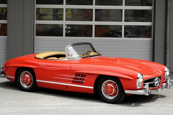 An old retro convertible of red color produced by Mercedes