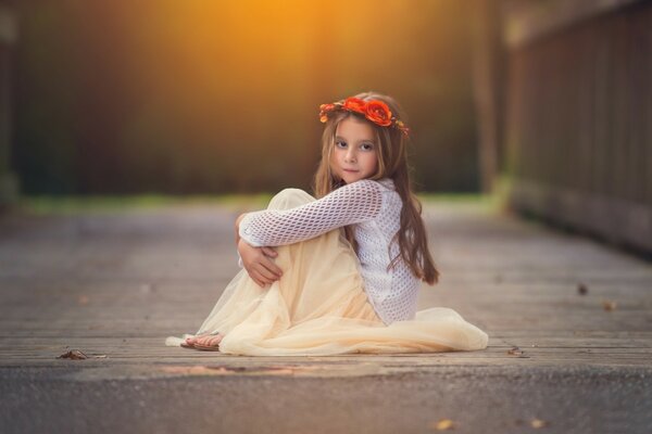 Bambino seduto con una corona di fiori