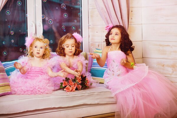 Girls in pink blowing soap bubbles