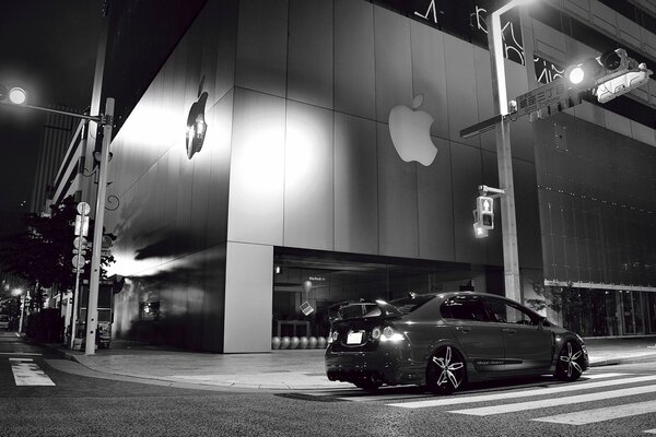 Schwarz-Weiß-Foto des Autos neben dem Apple-Gebäude