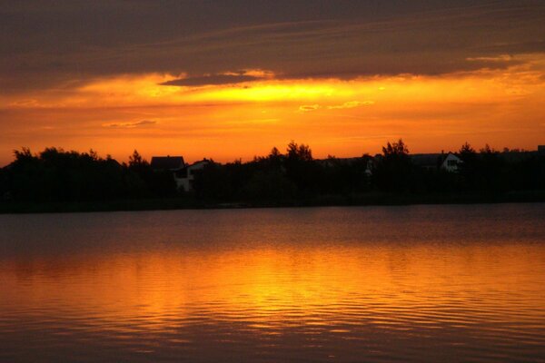 Summer lake under clouds at sunset