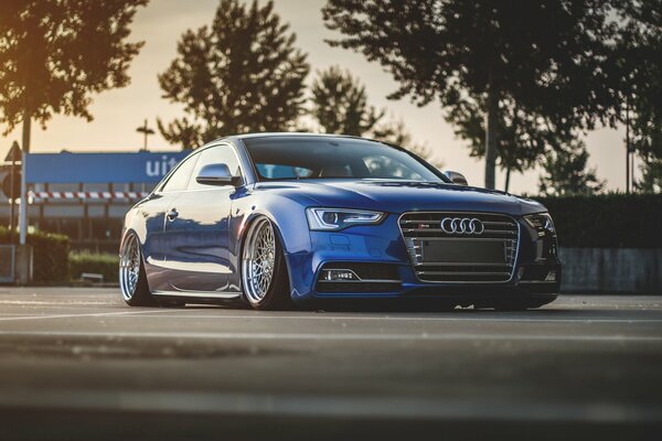 Understated blue Audi s5 on sunset background