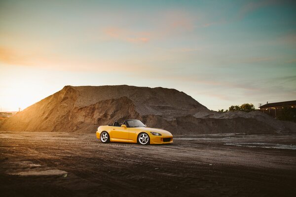 A tuned yellow Honda is in the mountains