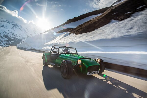 Un coche retro conduce por la carretera en medio de un paisaje invernal