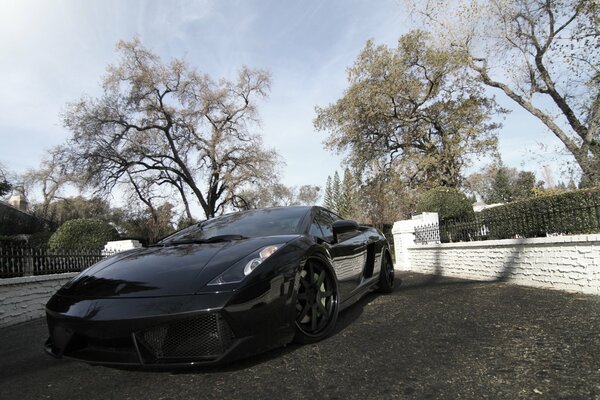 Das schwarze , getönte Auto ist ein Lamborghini gallardo, lp540-4, vor einem blauen Himmelshintergrund