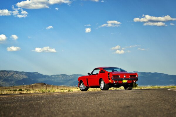 Ford Mustang rouge sur une route déserte