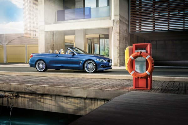 Elegante BMW alpina B4 convertible azul, en los rayos de luz