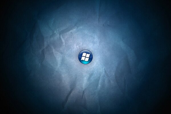 Das Windows-Logo auf einer blauen Schaltfläche auf einem zerknitterten Papierhintergrund