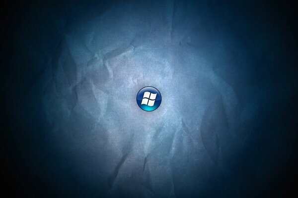 Logo di windows su un pulsante blu su sfondo di carta stropicciata