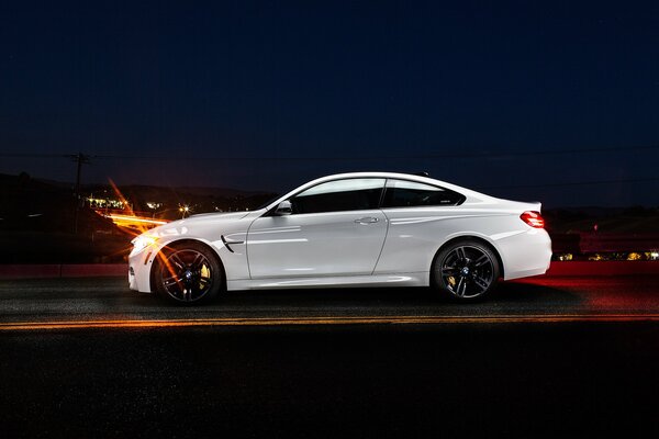 Blanc coupé BMW dans le profil de la nuit