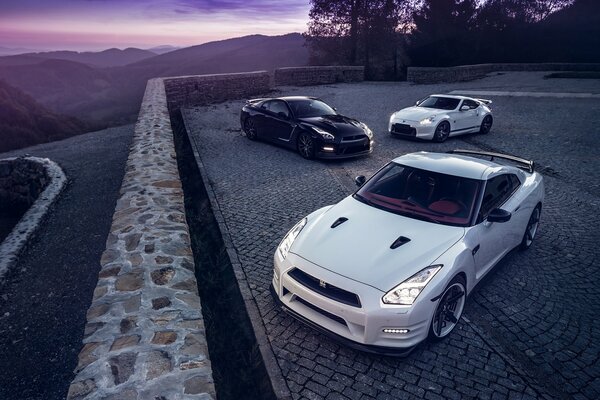 Белый nissan r35 с включенными фарами