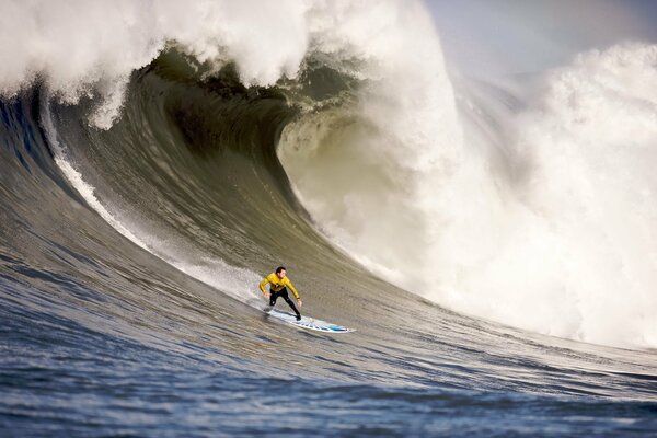 Surfista su una tavola su una grande onda di mare