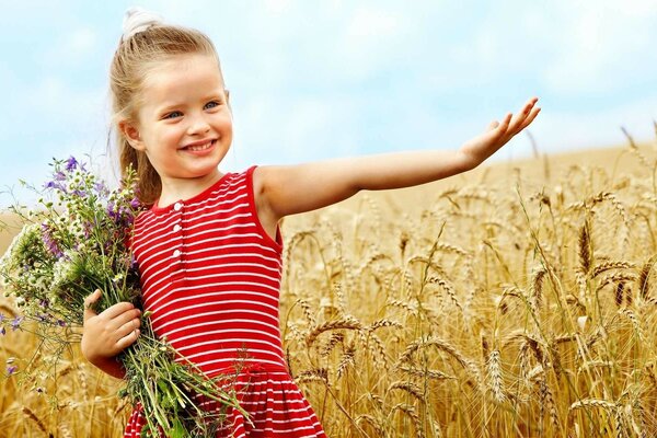 Enfant avec un bouquet de fleurs dans un champ de blé