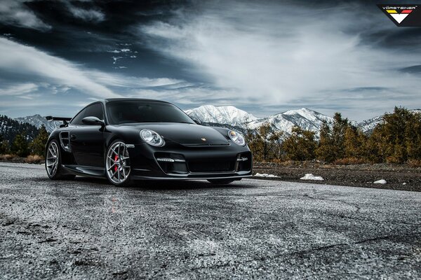 Negro Porsche 911 Tuning en el fondo de las montañas