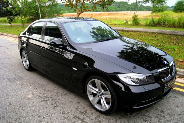 A black sedan car is parked on the road