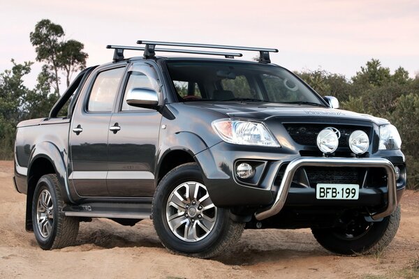 Black toyota hilux pickup truck on the sand