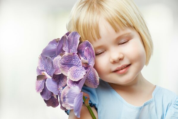 Petite fille avec des fleurs sur fond blanc