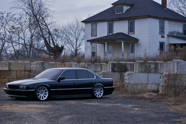 Black boomer on the background of an abandoned house