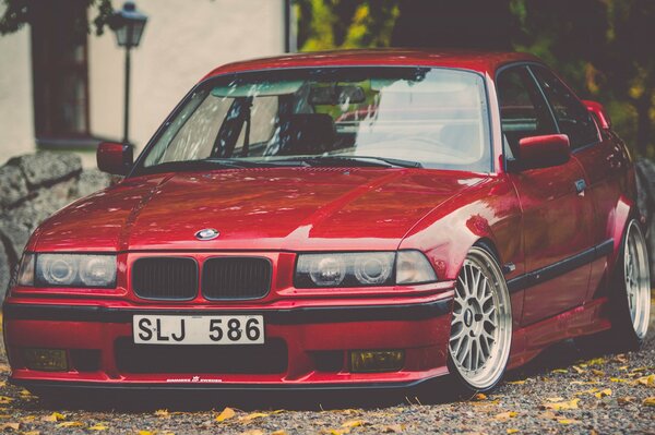 BMW E36 rojo en el patio en otoño