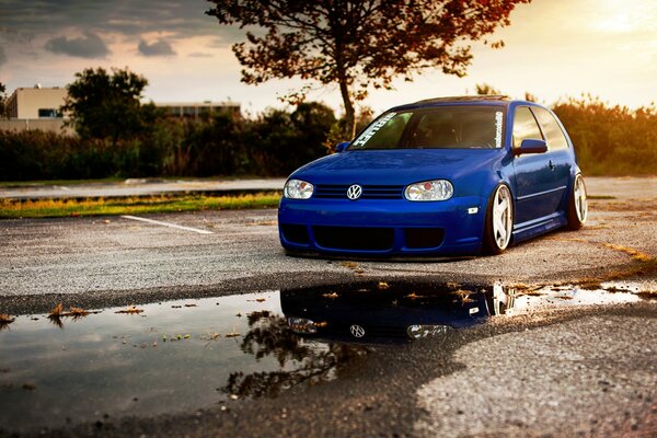 Volkswagen Golf blu sullo sfondo di un bel tramonto