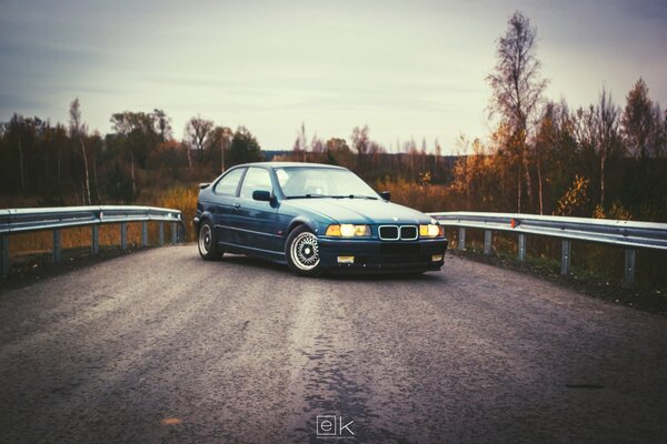 Blue bmw at the bump on the road