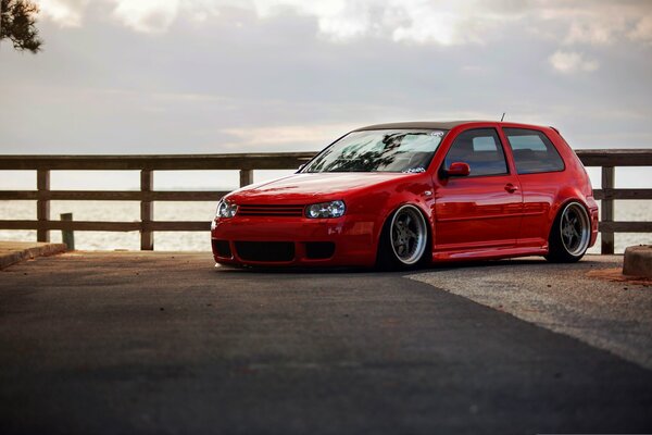 Red Volkswagen golf on the background of the sea