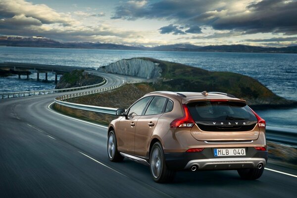 Volvo car rides on the road against the background of the sea
