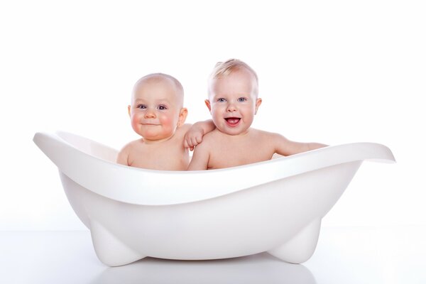 Zwei Babys baden in einer kleinen Badewanne