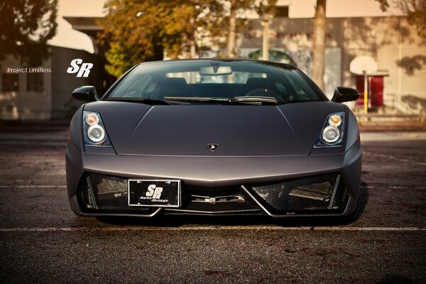 Un auto lamborginni Gallardo Immacolata in nero sullo sfondo di un paesaggio urbano