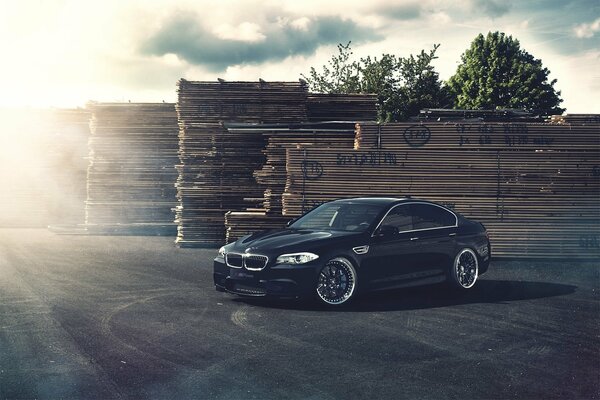 Czarne BMW na tle materiałów budowlanych