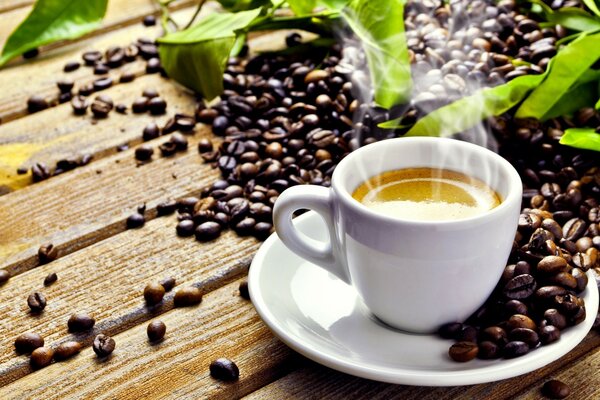 Tasse de café sur une assiette à côté des grains de café