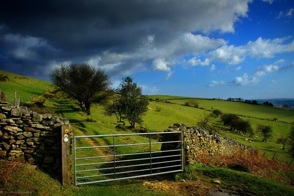 Puerta de entrada al campo bajo las nubes