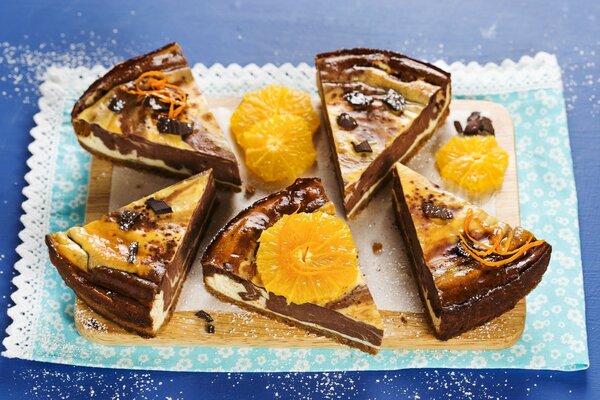 Cinco rebanadas de tarta de queso de chocolate con rodajas de naranja