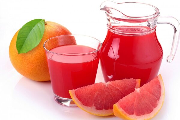 Pomelo y jarra con un vaso de jugo