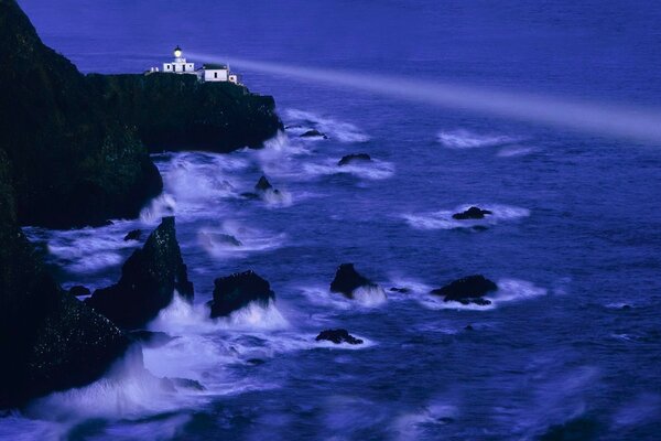 Lighthouse among rocks and waves