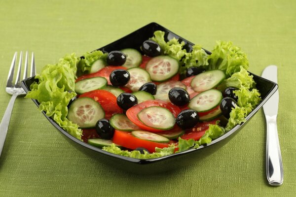 Salat mit Tomaten, Oliven und Gurken auf einem schönen Teller