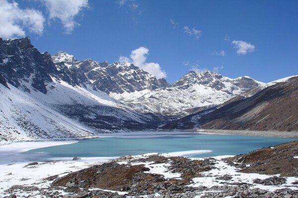 Montañas cubiertas de nieve en el vecindario de un lago helado