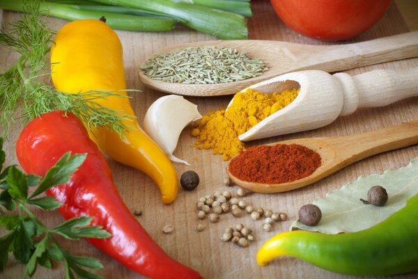 Peppers, vegetables and spices on a wooden table